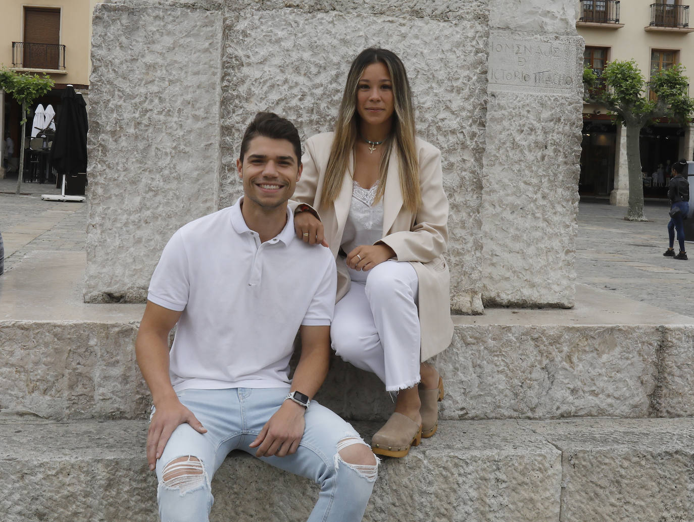 Daniel Méndez y Lydia Rubio, sentados a los pies del monumento de Victorio Macho a Berruguete, en la Plaza Mayor de Palencia. 