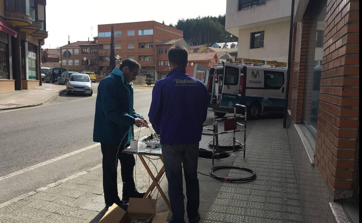 Dos técnicos de Telefónica instalan la red de fibra óptica en la localidad palentina de Guardo. 