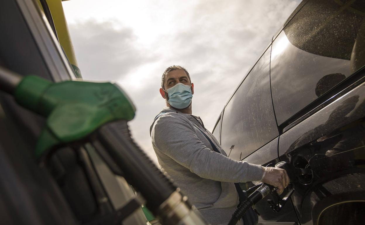 Un conductor reposta en una gasolinera.