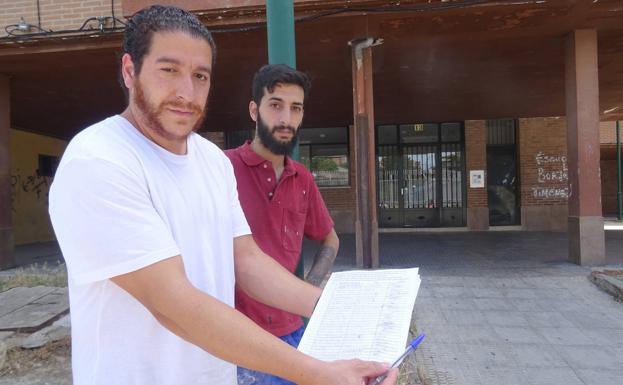 Israel y José muestran las firmas recogidas para pedir la marcha de la familia de las detenidas. 