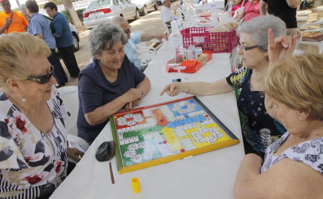 Un grupo de mujeres juegan al parchís. 