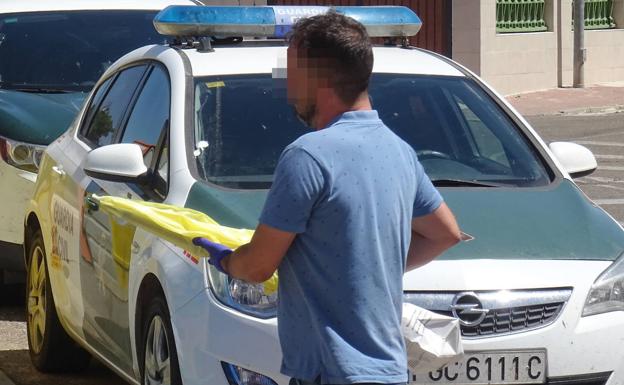 Un agente traslada el rifle intervenido en el domicilio de la familia del sospechoso. 