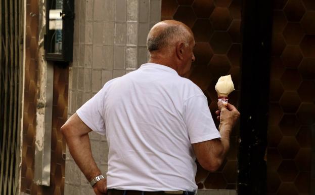 Un hombre come un helado por el centro de Valladolid. 