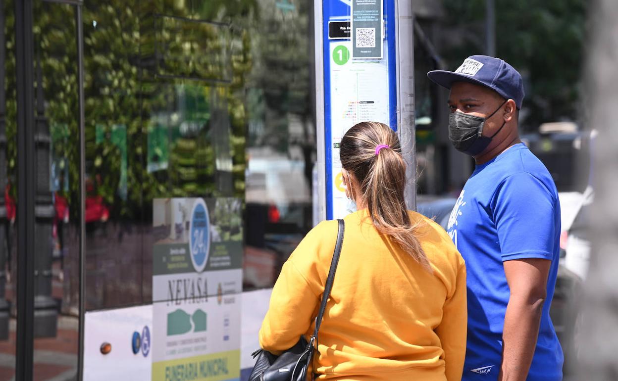 Ciudadanos en una marquesina del autobús de Valladolid con mascarilla. 