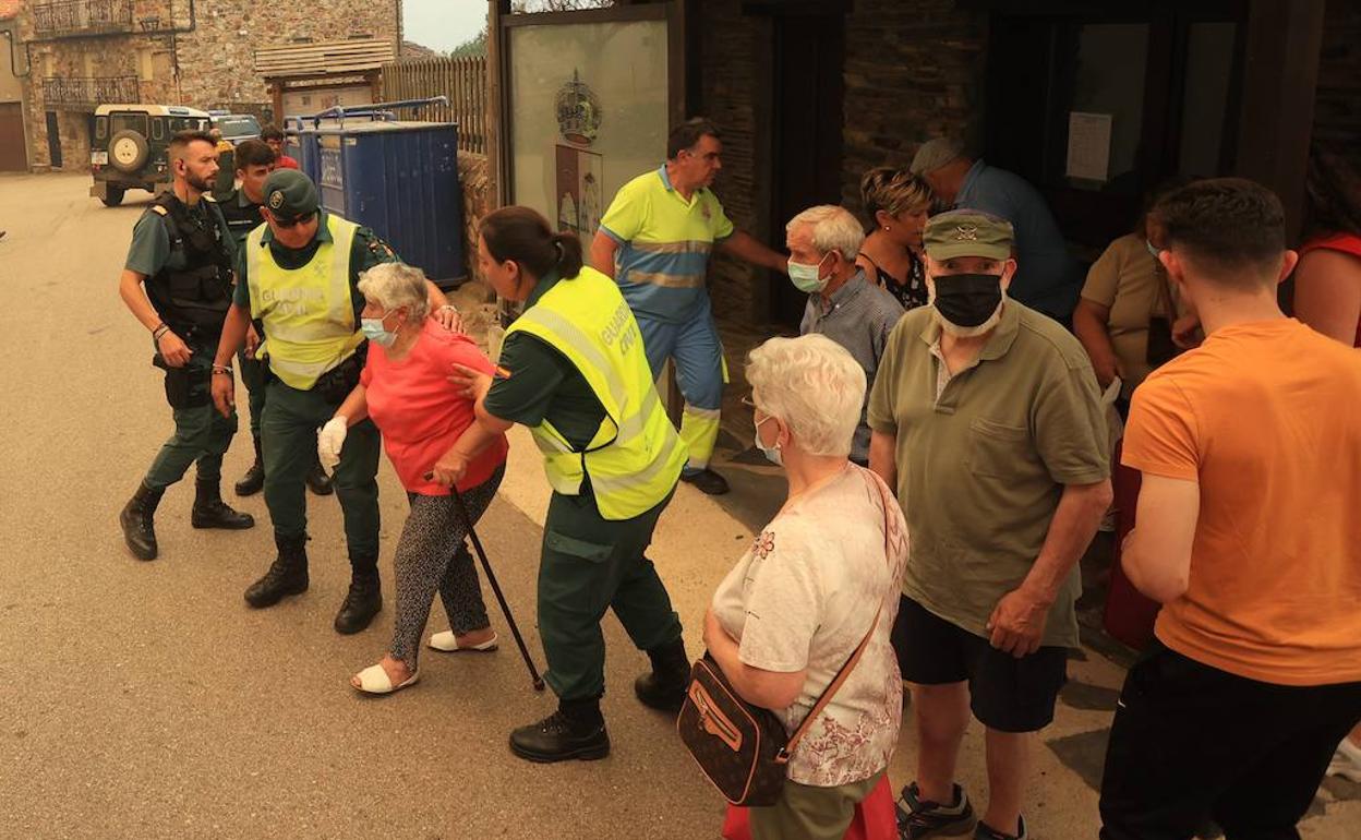 Guardias civiles y personal sanitario evacúan a los vecinos. 