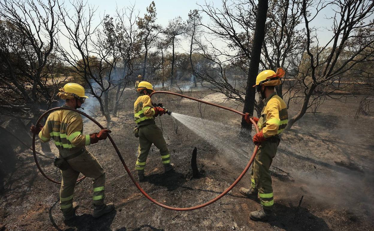 Los bomberos refescan la zona en la que se regsitro el incendio. 