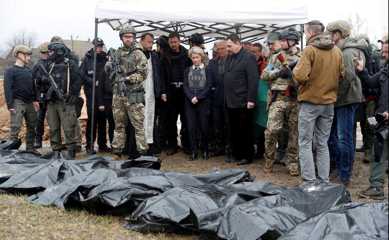 Representantes de la UE contemplan cuerpos embolsados asesinados por los rusos.