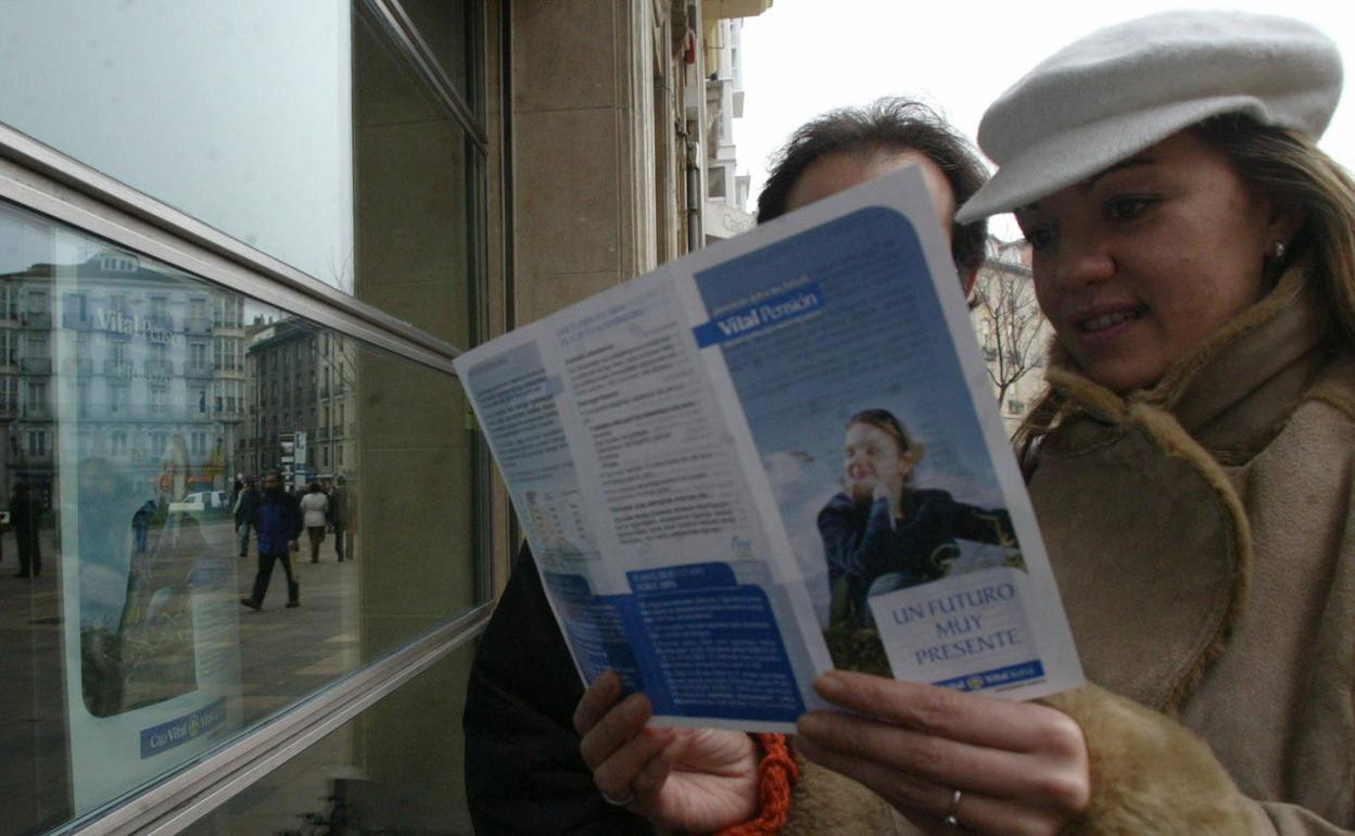 Una pareja consulta un folleto sobre planes de pensiones. 