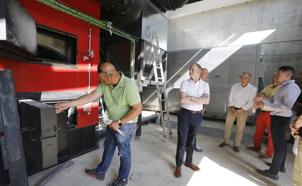 El rector de la UVA, y el vicerrector de Infraestructuras atienden a las explicaciones de la nueva caldera de biomasa del director de energías renovables del Somacyl, junto a otros responsables del campus de Palencia y de la obra de la red de calor.