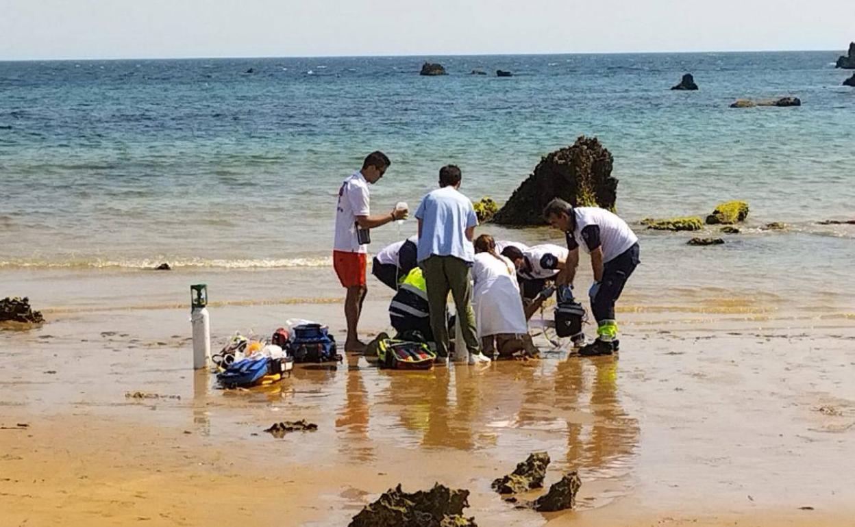 Equipos sanitarios atienden al hombre en la playa de Noja.