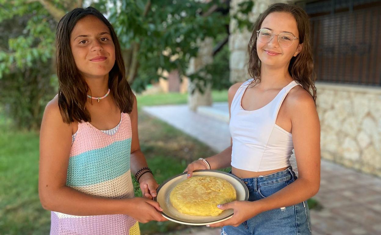 Blanca y Marta muestran la tortilla lista para comer. 