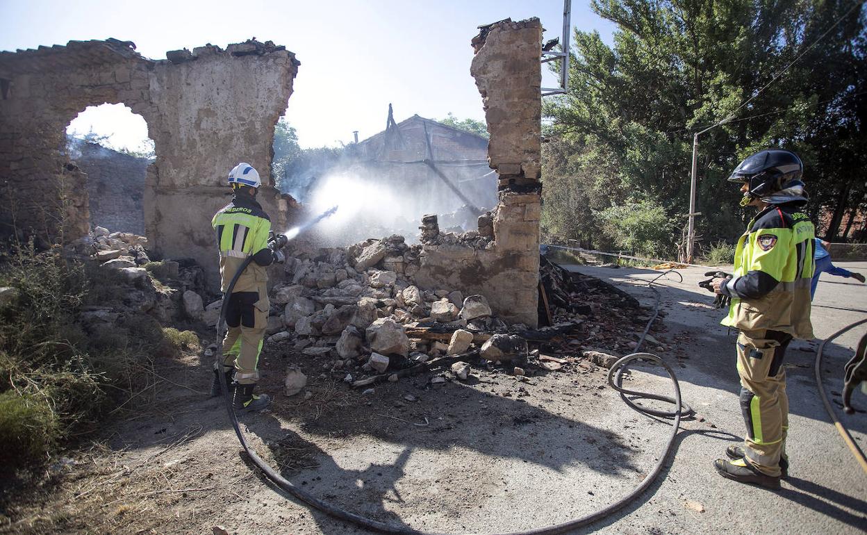 Los bomberos refrescan una zona para evitar que se reaviven las llamas en la comarca del Arlanza. 