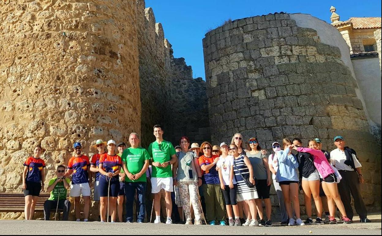 Participantes en la marcha posan ante las muralla de Urueña. 