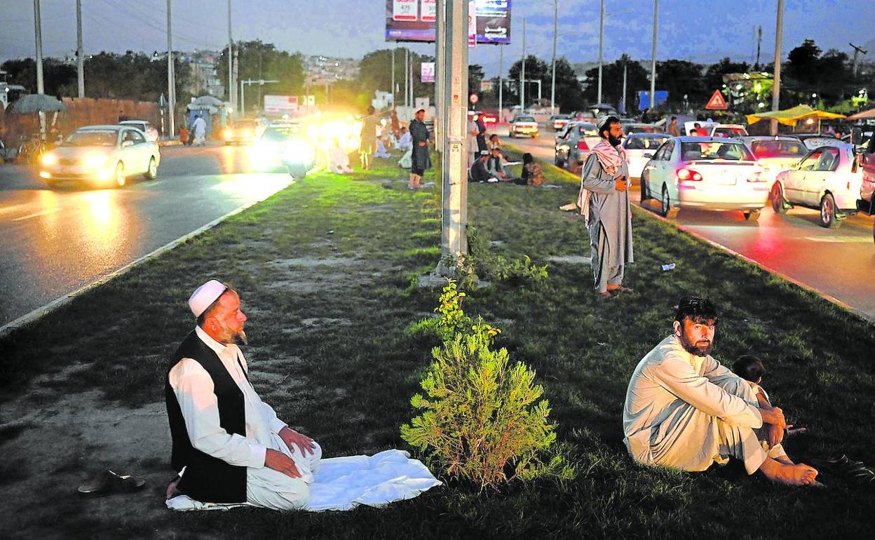 Un grupo de musulmanes reza en un arcén de una carretera de Kabul