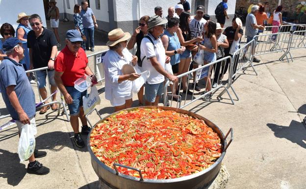 Los asistentes aguantaron bajo el sol al reparto de paella. 