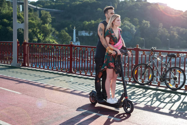 Una pareja se desplaza en patinete eléctrico, acción que acarrea una multa.