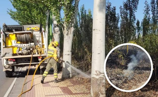 Los Bomberos refrescan la zona junto a la acera en la Carretera del Cementerio