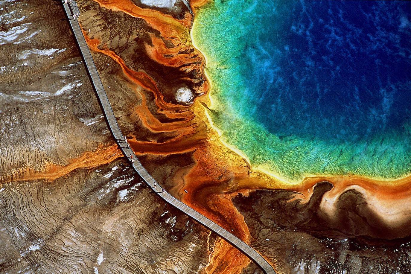 GRAN FUENTE PRISMÁTICA (PARQUE NACIONAL YELLOWSTONE, WYOMING, EE.UU.) | Este tesoro de colores, con tonalidades rojizas, ocres, verdosas, naranjas y azules, atrae a viajeros de todo el mundo. Desde que en 1839 fuera descubierto de forma casual por Osborne Russell, este fenómeno natural de colores casi irreales no ha perdido un ápice de interés entre el gran público. El secreto se esconde en los ricos minerales y las bacterias pigmentadas que crecen en los márgenes de la laguna.