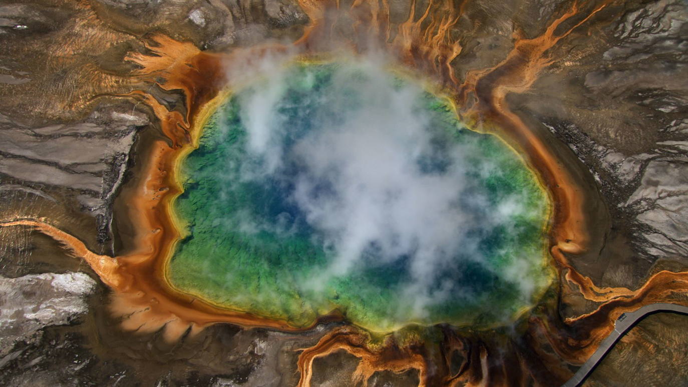 GRAN FUENTE PRISMÁTICA (PARQUE NACIONAL YELLOWSTONE, WYOMING, EE.UU.) | Este tesoro de colores, con tonalidades rojizas, ocres, verdosas, naranjas y azules, atrae a viajeros de todo el mundo. Desde que en 1839 fuera descubierto de forma casual por Osborne Russell, este fenómeno natural de colores casi irreales no ha perdido un ápice de interés entre el gran público. El secreto se esconde en los ricos minerales y las bacterias pigmentadas que crecen en los márgenes de la laguna.