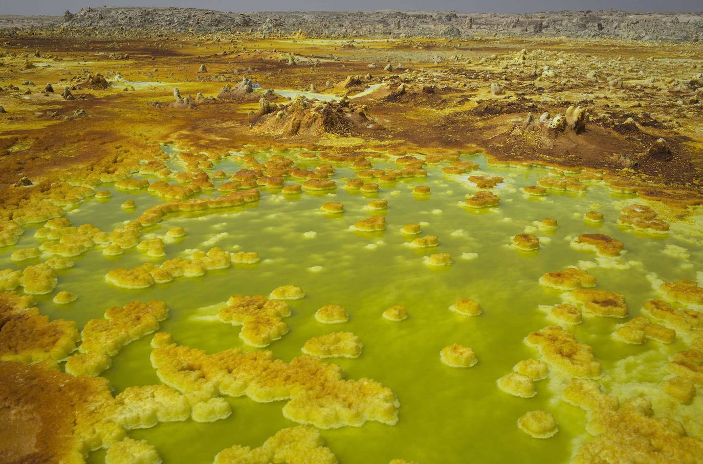 LAGOS ÁCIDOS DE DALLOL (ETIOPÍA) | Dallol se encuentra en el noreste de Etiopía, en la región de Afar, concretamente en la depresión de Danakil, a 48 metros bajo el nivel del mar. Su volcán está rodeado de colinas de azufre natural que alcanzan una altura de 60 metros y tienen vivos colores como blanco, amarillo, turquesa y rojo. Son el resultado de la coloración de las sales de potasio por varios iones.