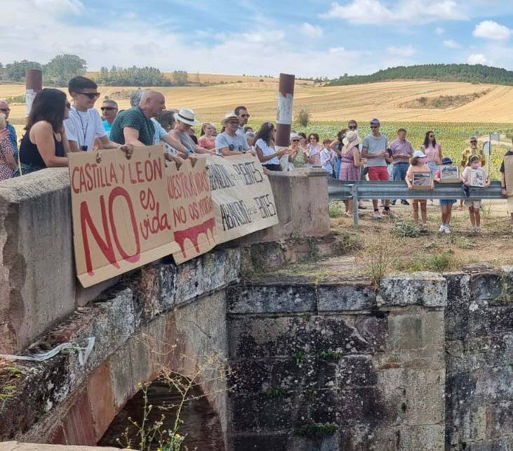 Participantes en la protesta, con pancartas para reclamar la mejora de los puentes, este domingo en Zarzosa de Riopisuerga. 