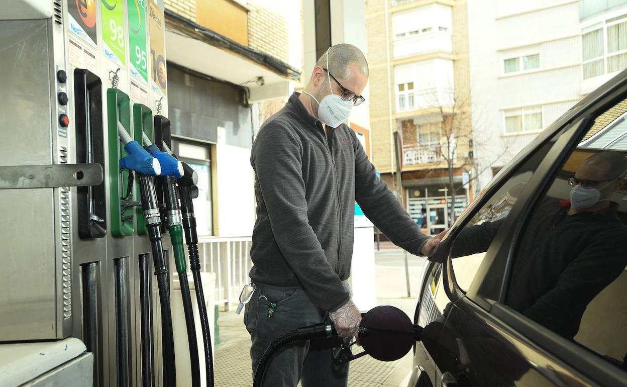 Hombre respotando en una gasolinera. 