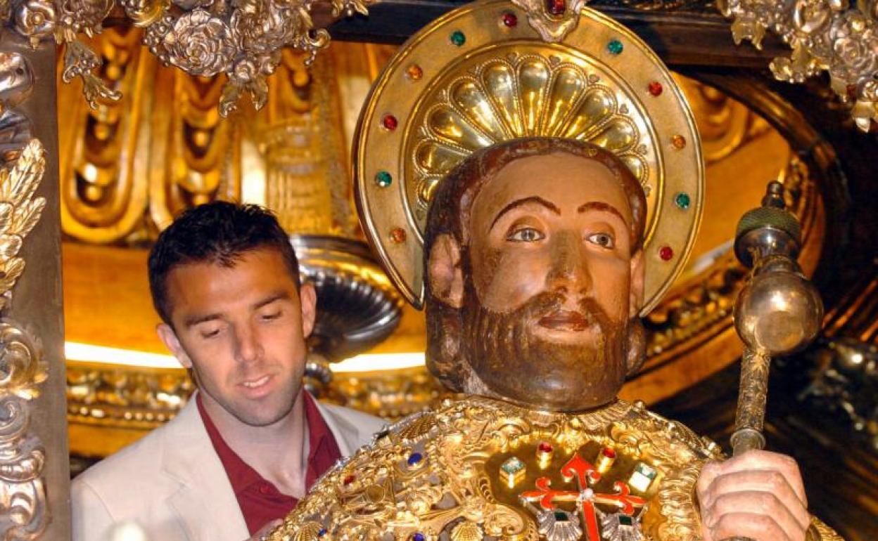 Un jugador de fútbol abraza al Santo, durante una ofrenda al Apóstol de los integrantes de la Selección. 