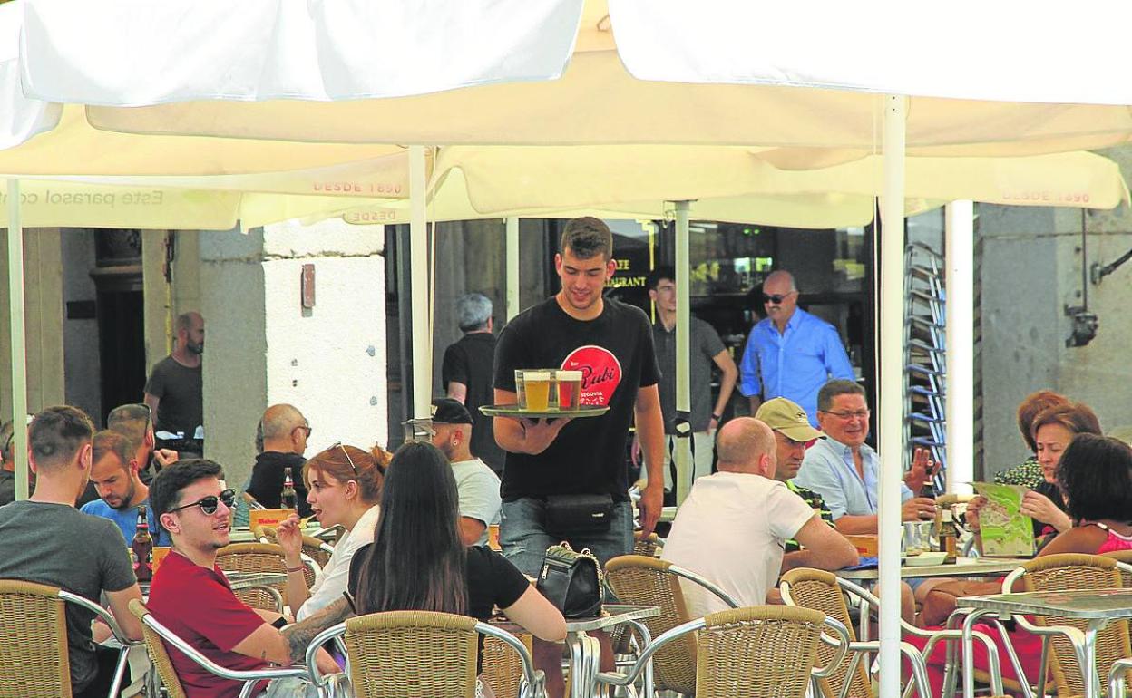 Un camarero sirve una terraza en el centro de la capital segoviana.