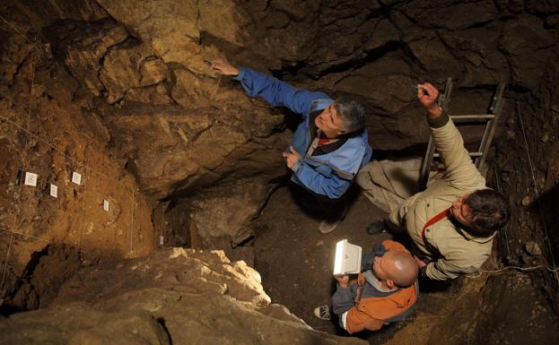 Tres científicos trabajando en la cámare este de la cueva de Denisova.