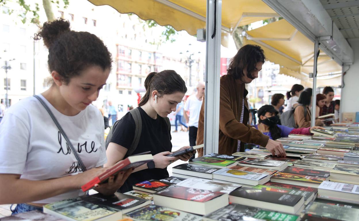 Dos jóvenes miran libros, uno de los productos que se pueden adquirir con el bono cultural. 