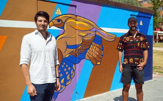 Rubén Bugeda y Manu Salviejo frente al mural 'Busardo', en una caseta de transformación de Arroyo 