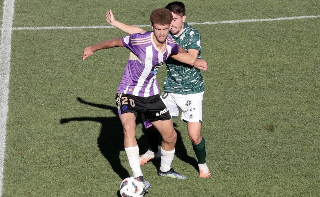Quintana se protege de un jugador del Guijuelo. 