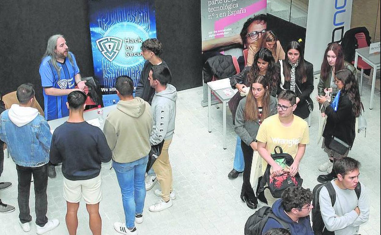 Los estudiantes universitarios visitan los expositores. 
