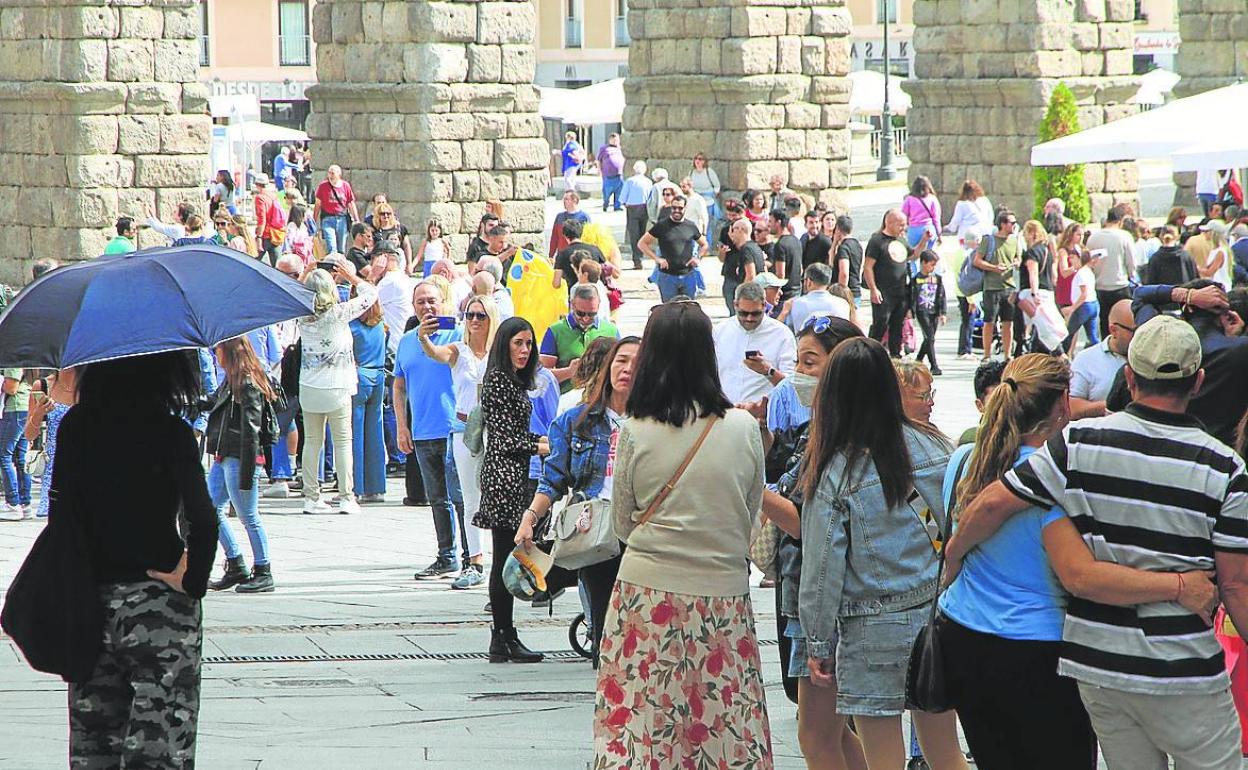 Grupos de visitantes pasean y sacan fotos en el entorno del Acueducto, est sábado. 