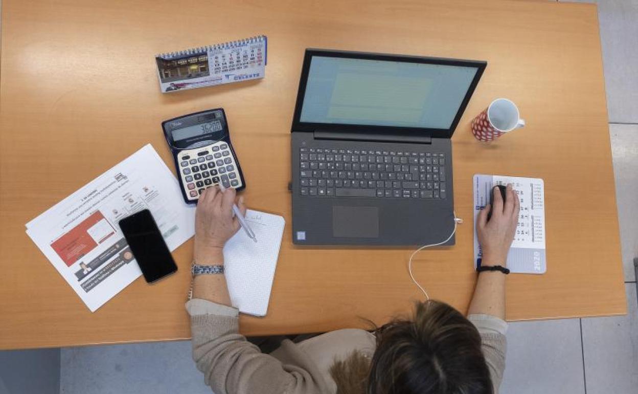 Una mujer en su mesa de trabajo desde casa. 