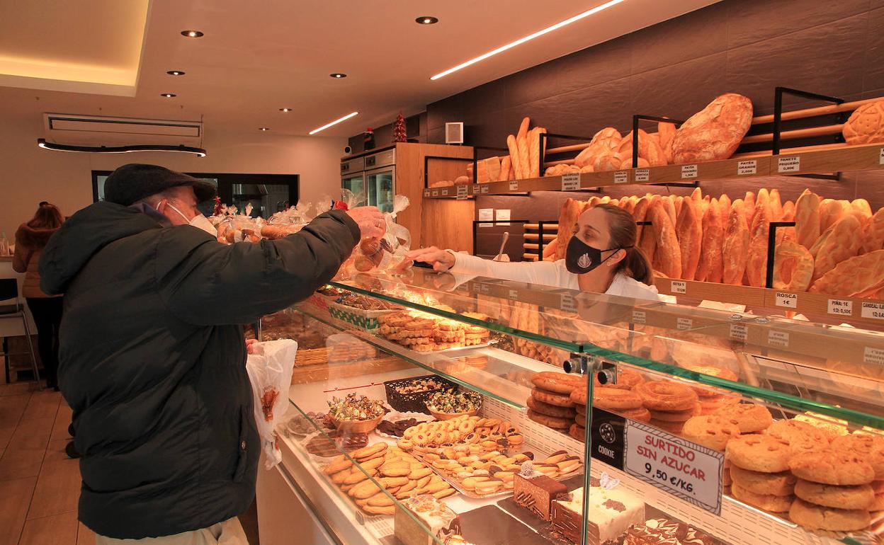 Un cliente compra el pan en una tienda de Segovia. 