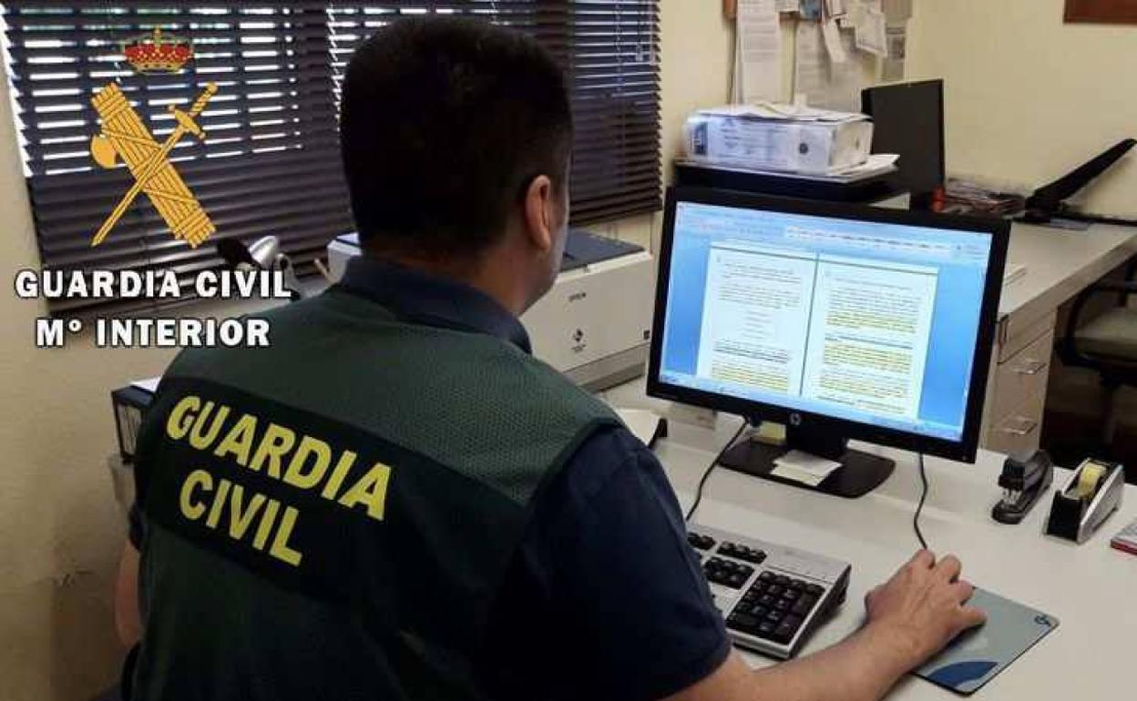 Un agente de la Guardia Civil investiga un posible delito de estafa informática. 