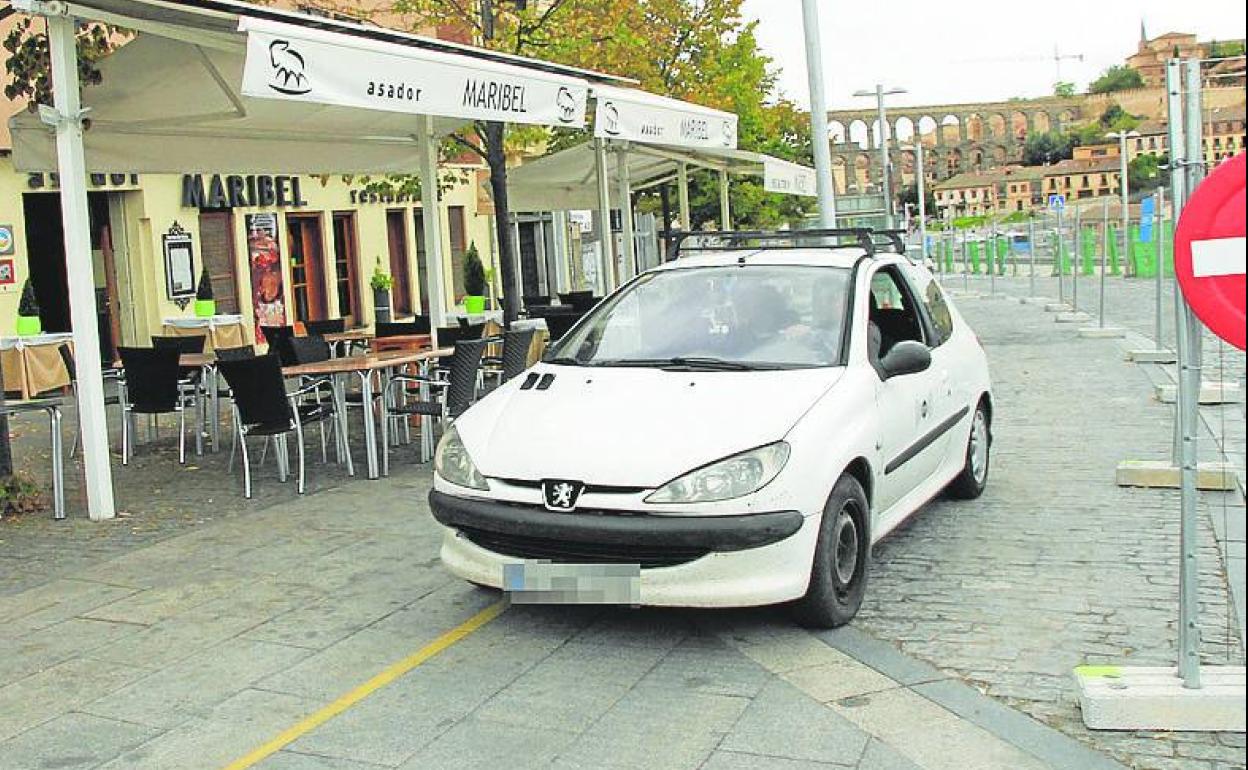 Un vehículo rebasa los límites de una terraza en el carril de subida. 