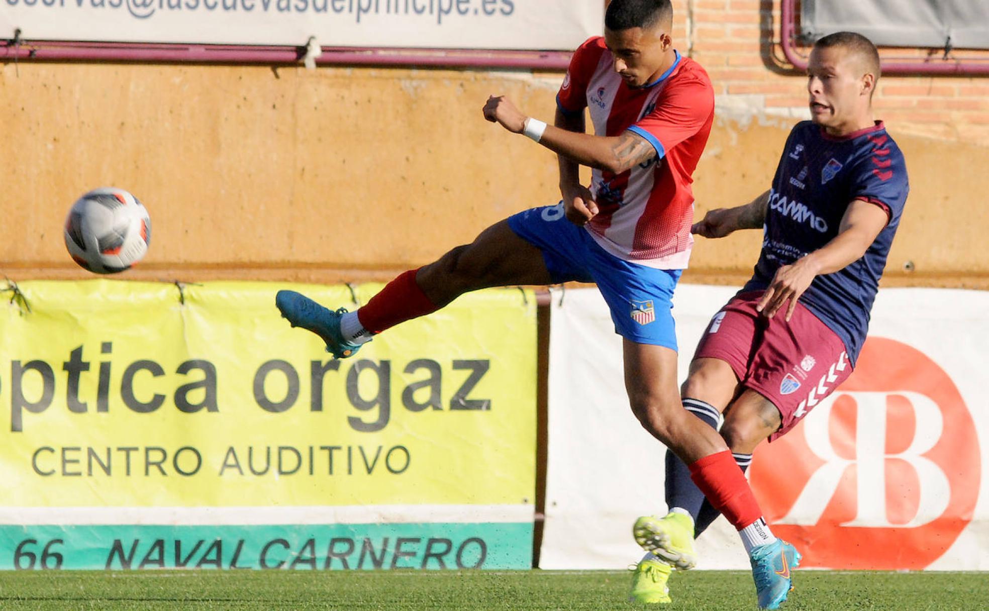 El jugador segoviano Borao encima a un rival del Navalcarnero en el partido disputado este domingo. 