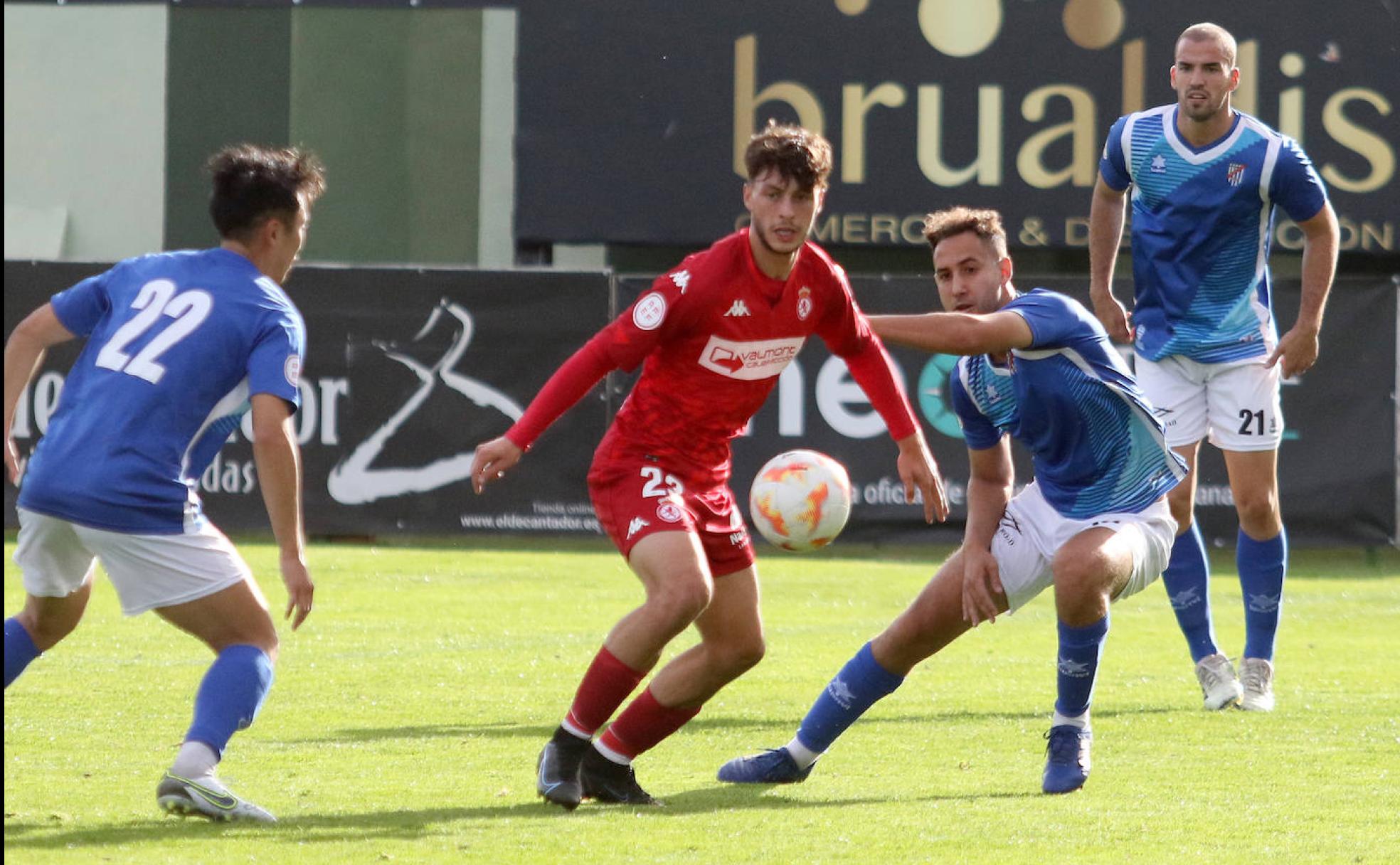 Jugdores del Unami rodean a un adversario del Júpiter Leonés en el partido de este sábado en La Albuera. 