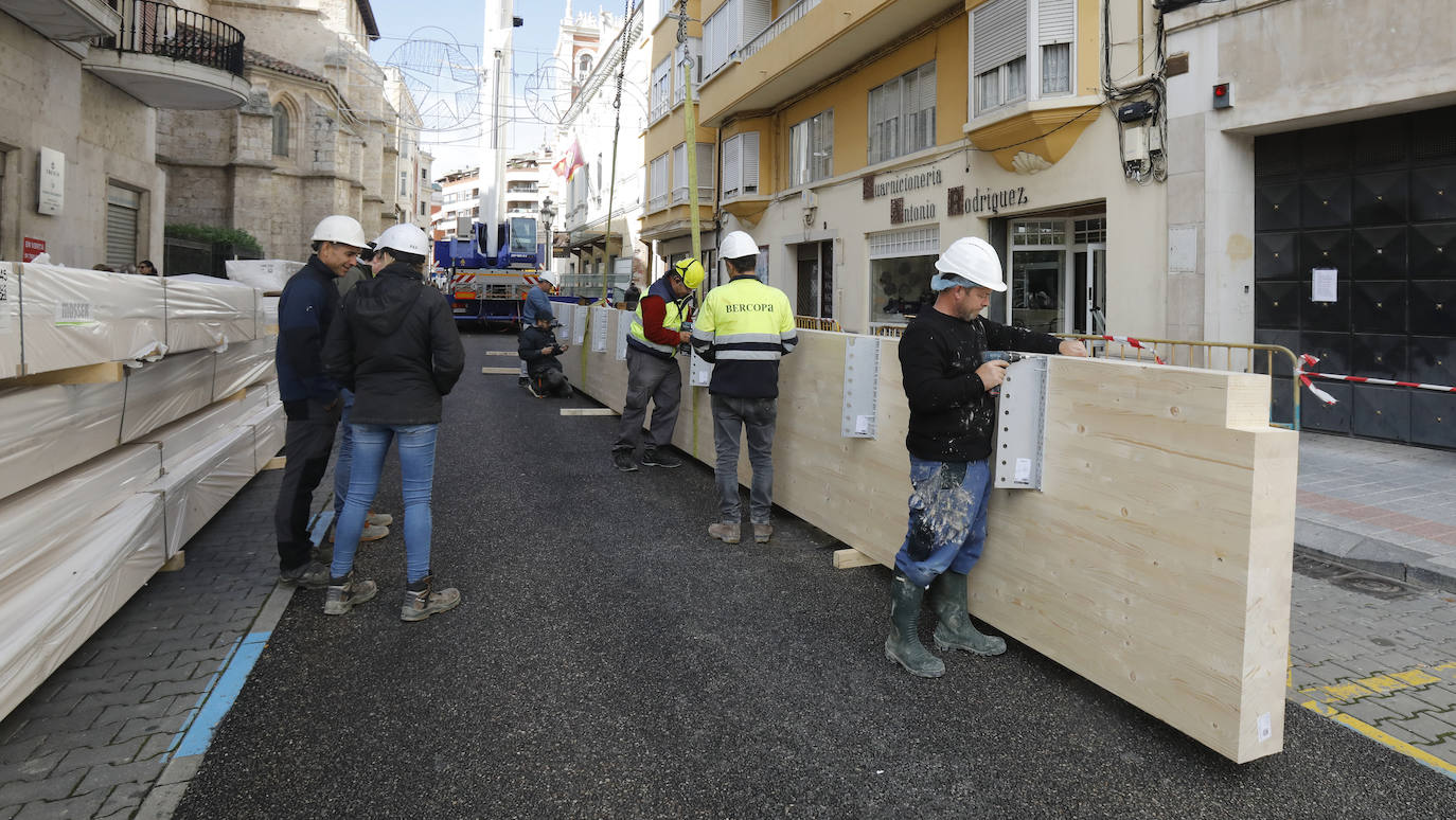 Una grúa de grandes dimensiones trabaja en la calle Burgos para colocar decenas de vigas de madera de tamaño gigante.