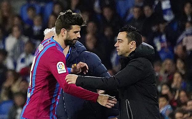 Xavi y Piqué se saludan tras una sustitución esta temporada..
