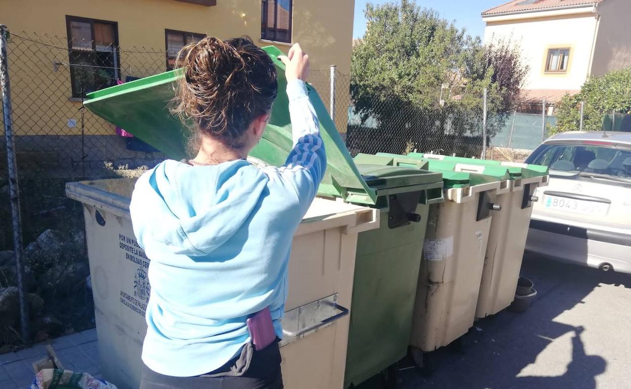 Una vecina tira la basura en Palazuelos de Eresma. 