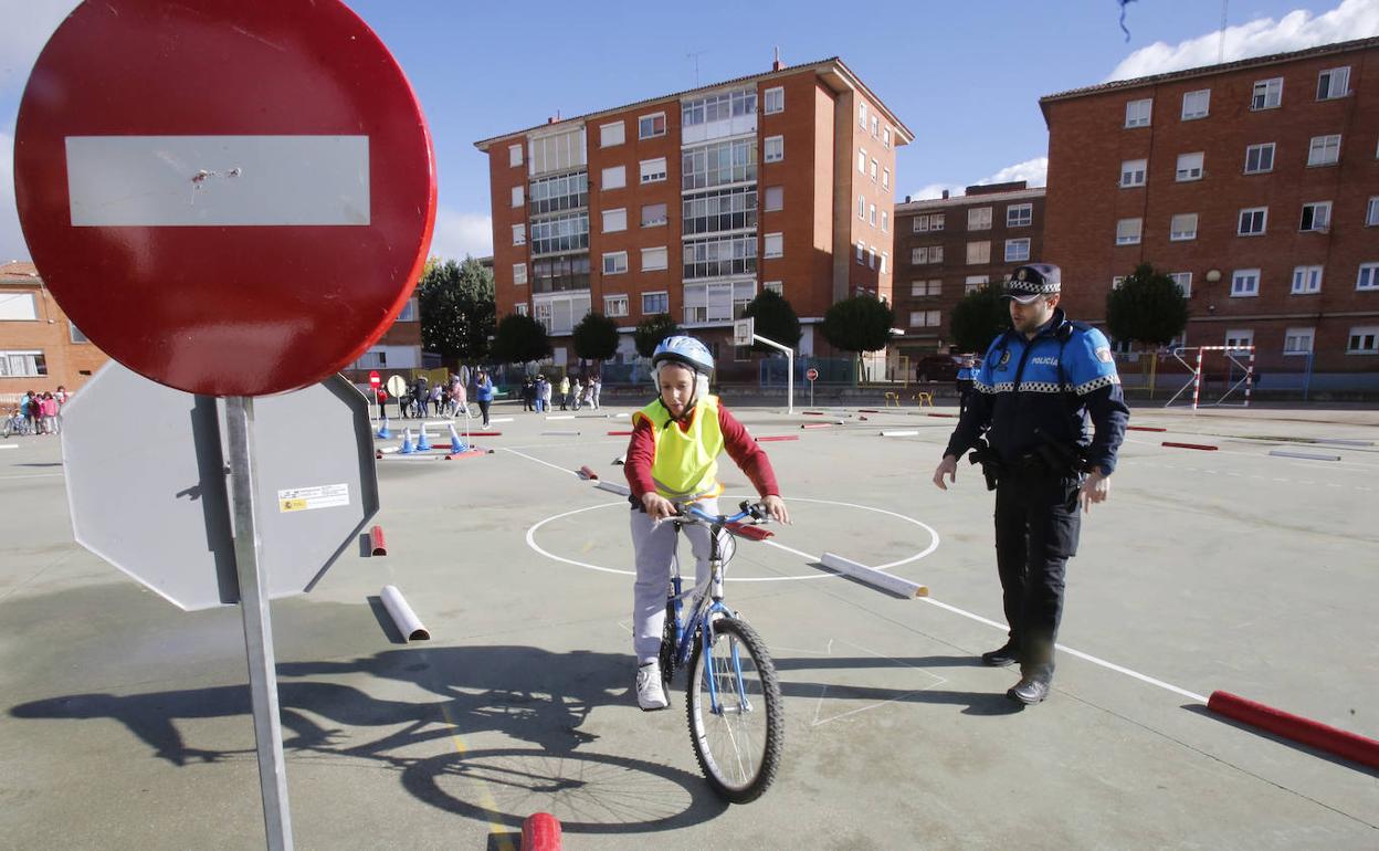 Uno de los agentes tutores observa cómo un alumno del Ave María de quinto de Primaria realiza el circuito en bicicleta. 