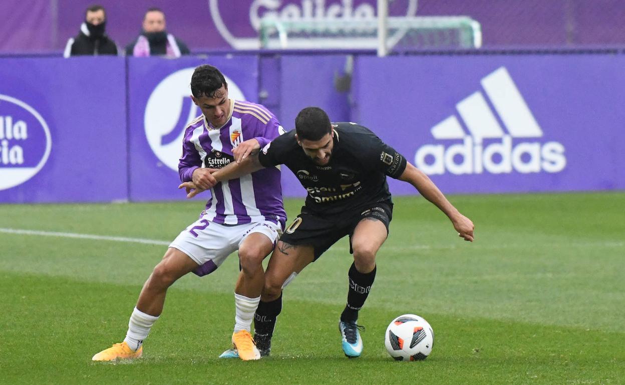 El jugador blanquivioleta Iker Pérez trata de impedir el avance de un jugador del Laredo. 