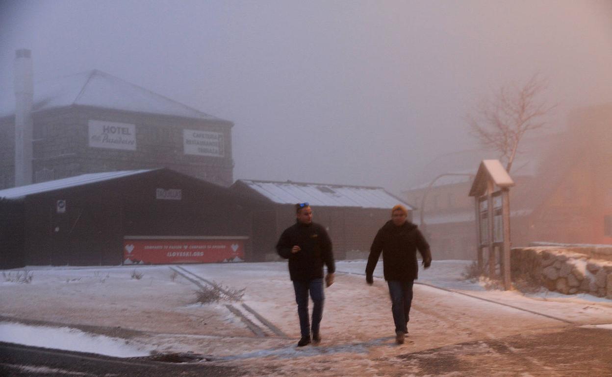 Dos personas transtan sobre la nieve caída este viernes en Navacerrada. 