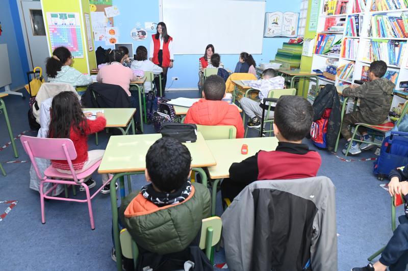 Los menores escuchan las explicaciones de una de las voluntarias de Cruz Roja. 