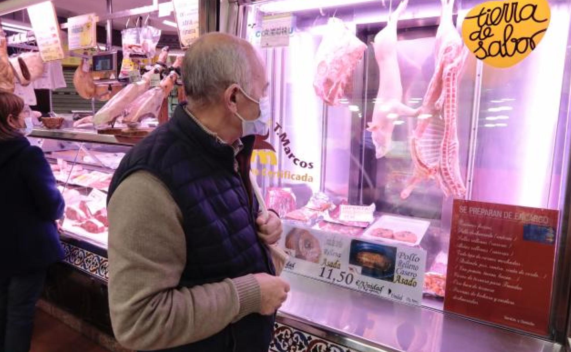 Un hombre mira los precios en una carnicería 