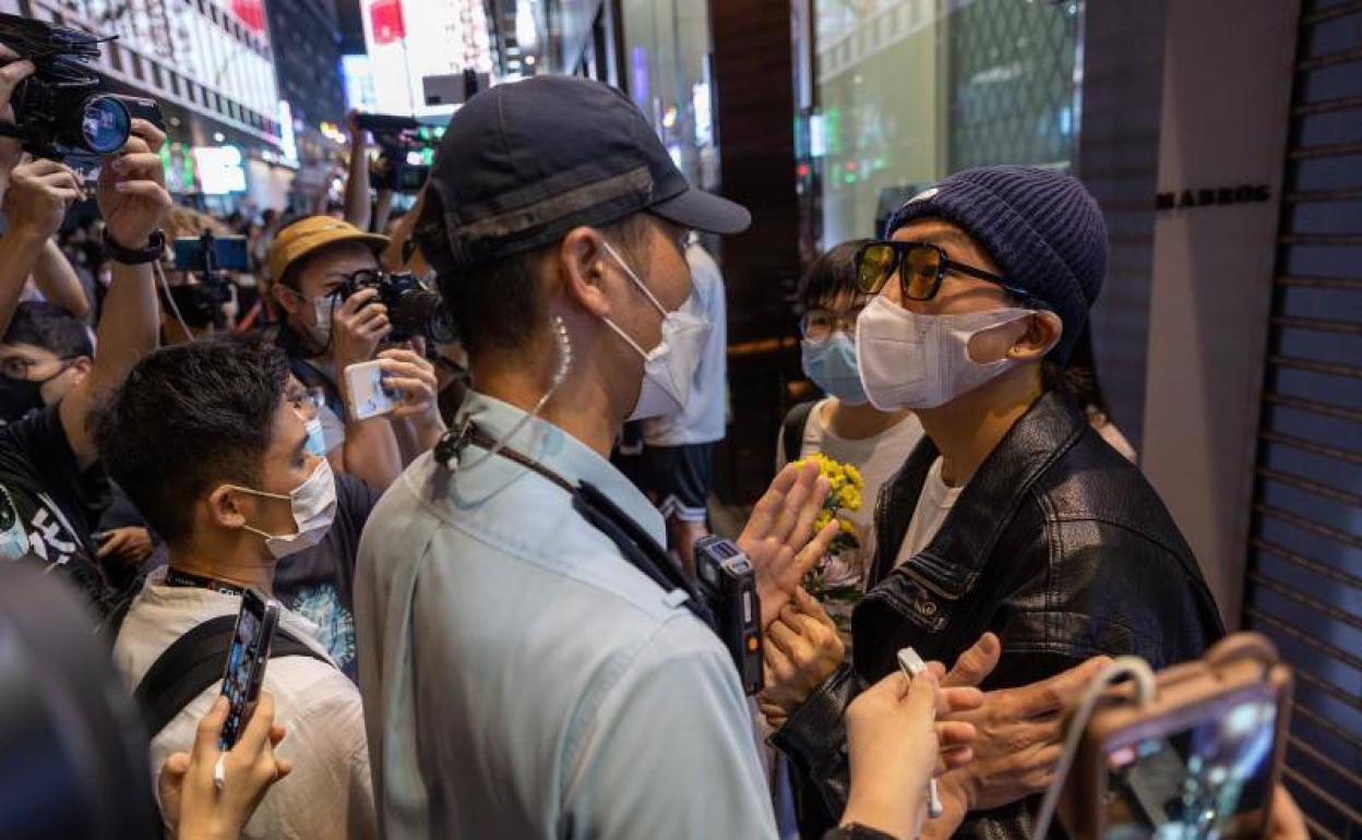 Un hombre se encara con un policía durante una vigilia por las víctimas del covid, este lunes en Hong Kong.