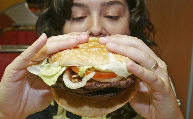 Una mujer instantes antes de comer una hamburguesa. 